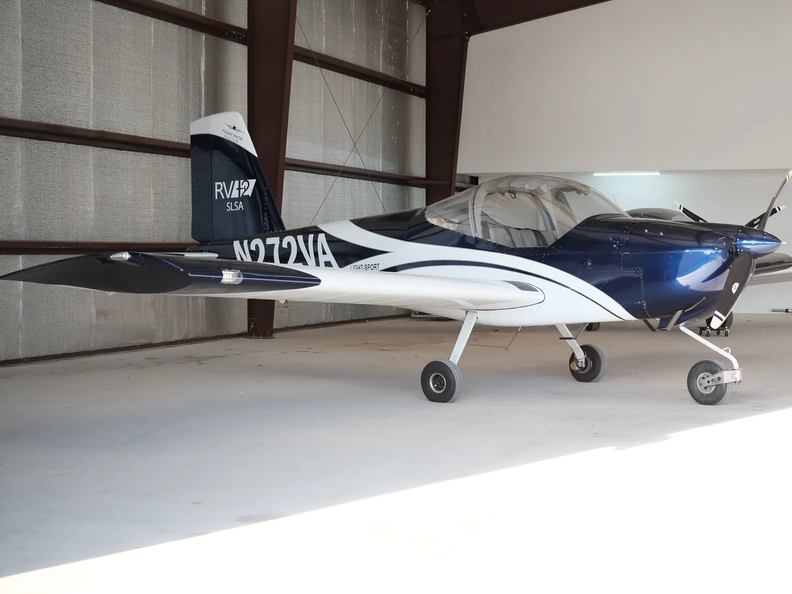 N272VA, a blue and white Van's RV-12, parked inside a hangar