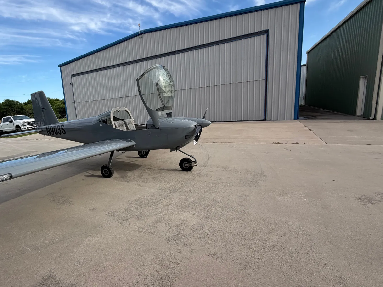 N903S, a Van's RV-12iS, parked on the ramp outside a hangar with the canopy open
