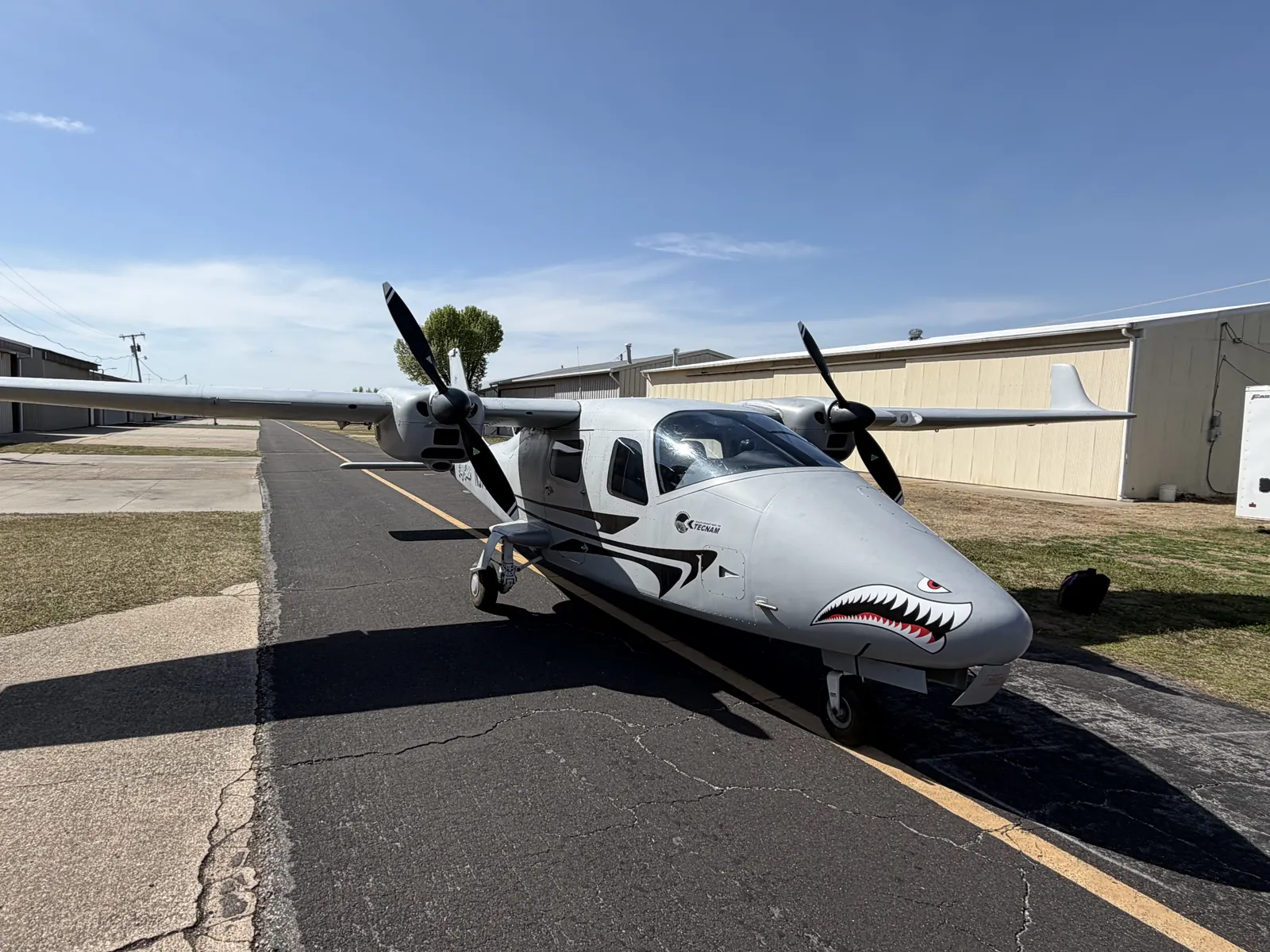 N977GV, a gray Tecnam P2006T twin with shark mouth nose art, on the taxiway